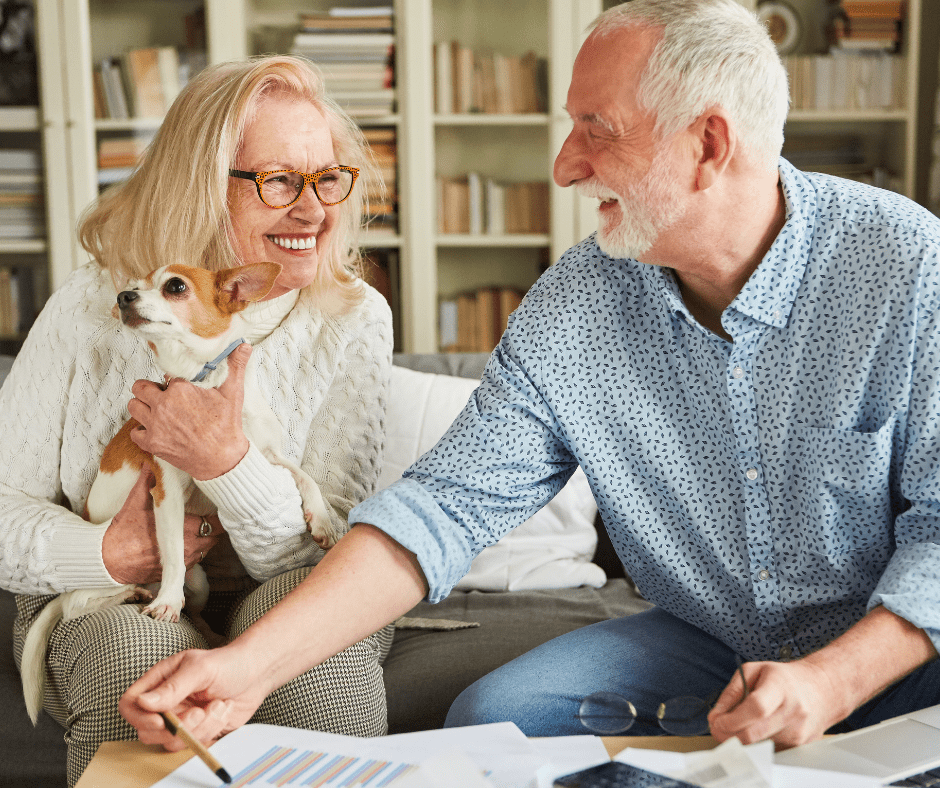 April 25 Events Page Image - The Magnolia at Oxford Commons Elderly man and his wife smiling and holding small dog
