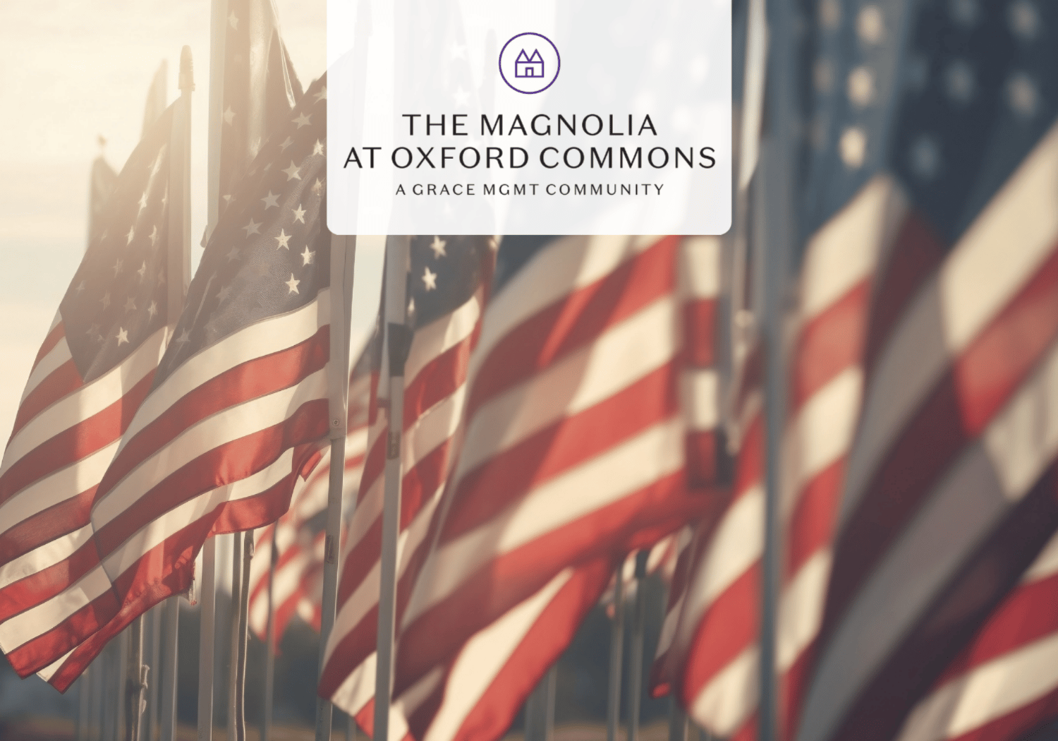 Row of American flags with a white translucent banner displaying 'The Magnolia at Oxford Commons' logo above.