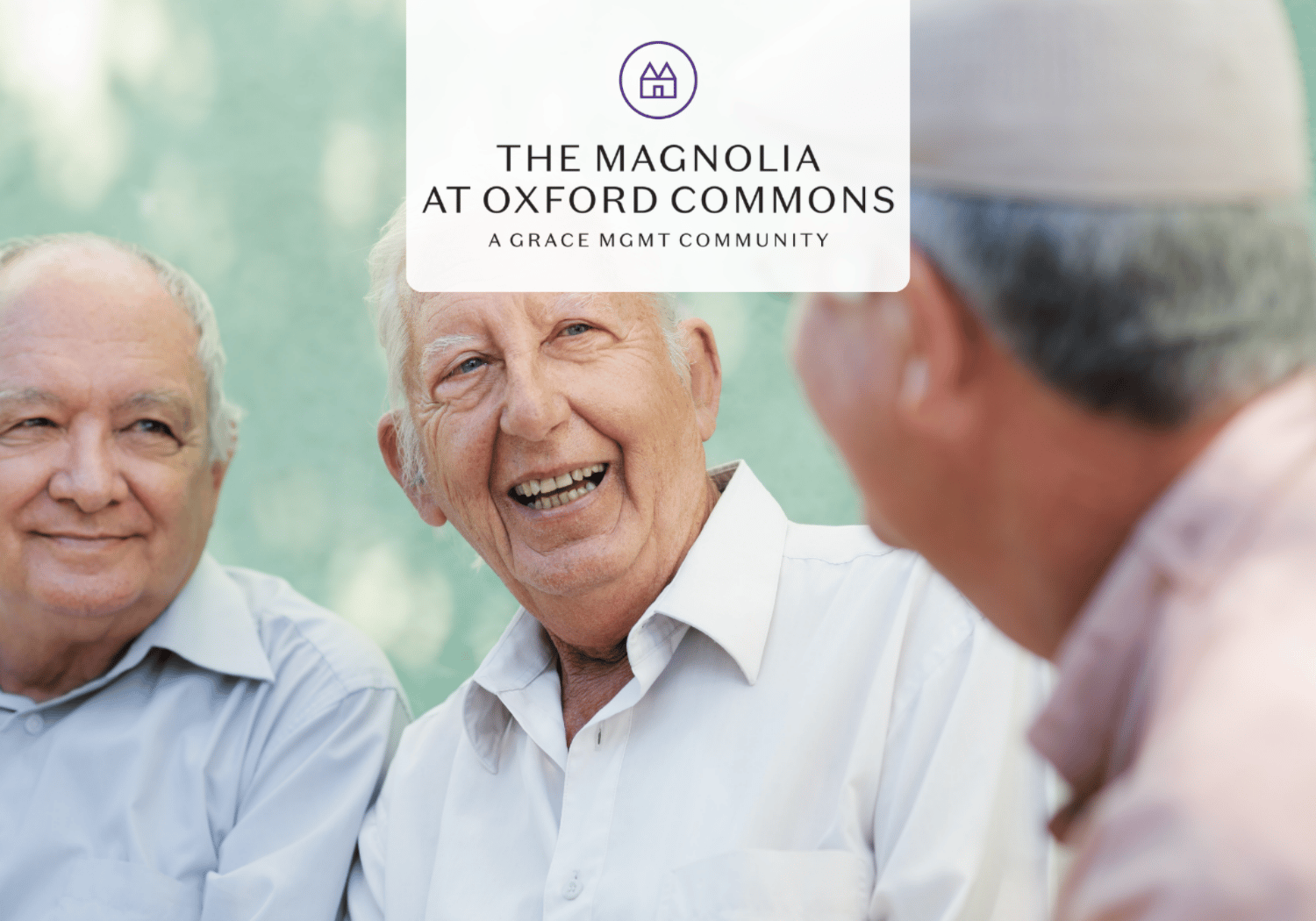 Three smiling elderly men chat outdoors with a white logo overlay reading The Magnolia at Oxford Commons, a Grace MGMT community.